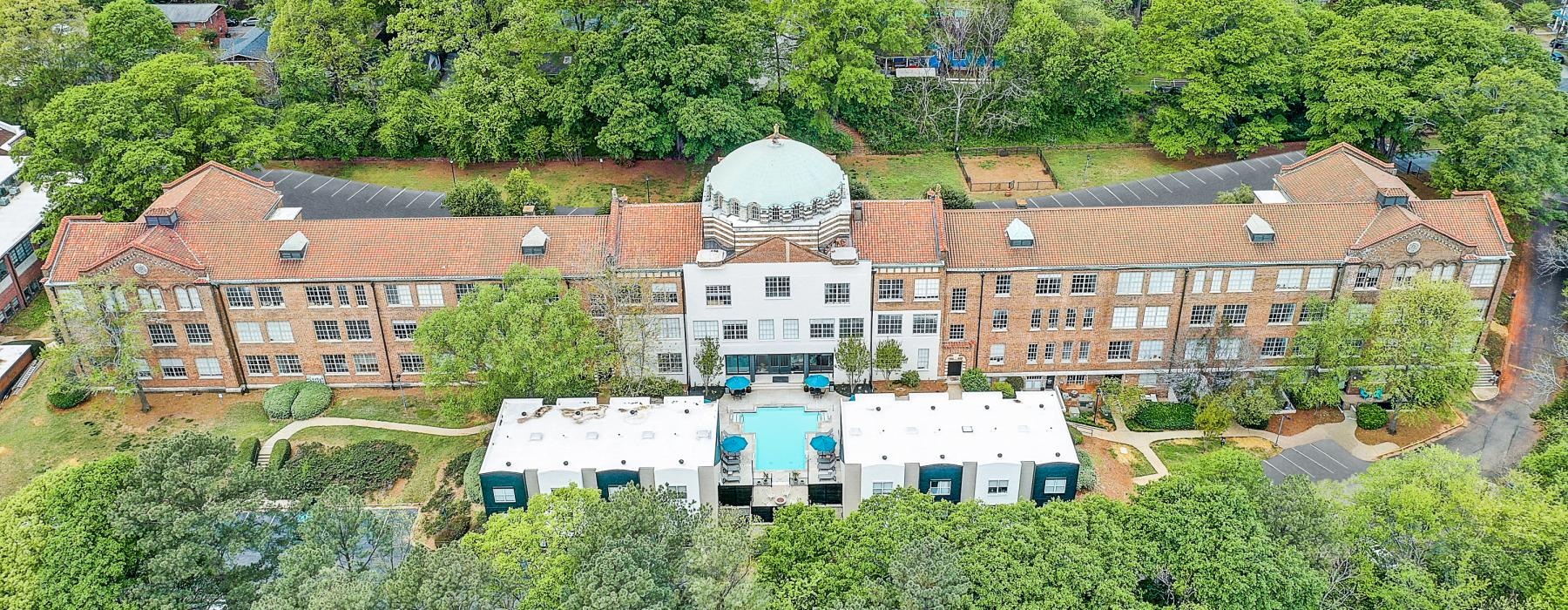 a large building with a dome on top surrounded by trees