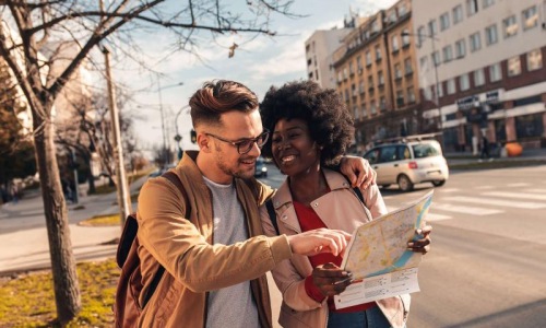 a man and woman looking at a map in the city